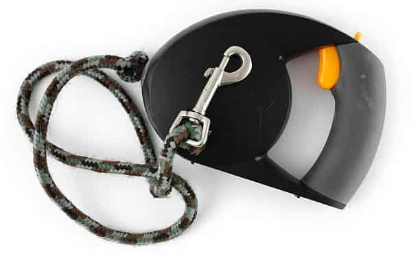 "Close up shot of a retractible dog leash isolated on a white background. The well-used dog walker had a bright yellow trigger release, a gray handle, and a brown and black rope. 